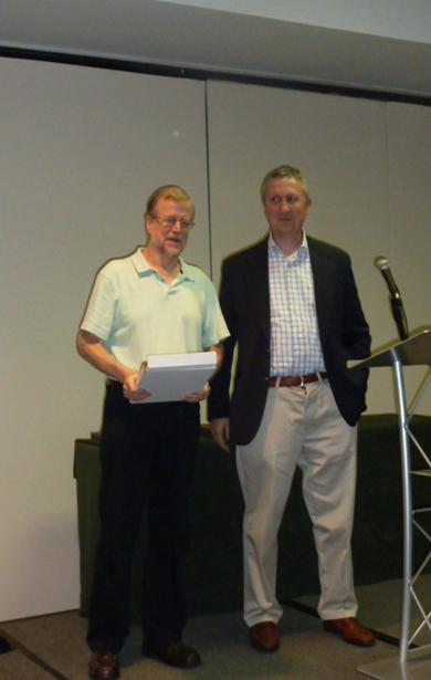 Vernon Henderson (left) receiving a plaque from Gilles Duranton